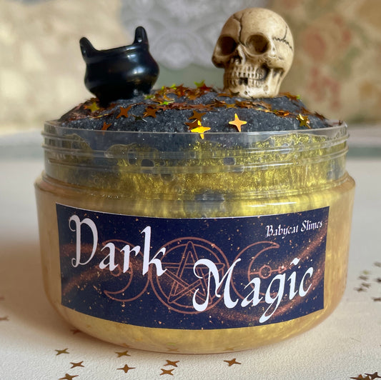 Sparkly gold slime with black cloud slime on top, skull and cauldron charms, Halloween themed
